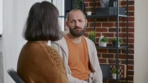 Mann spricht mit einer Frau und sieht bedrückt aus